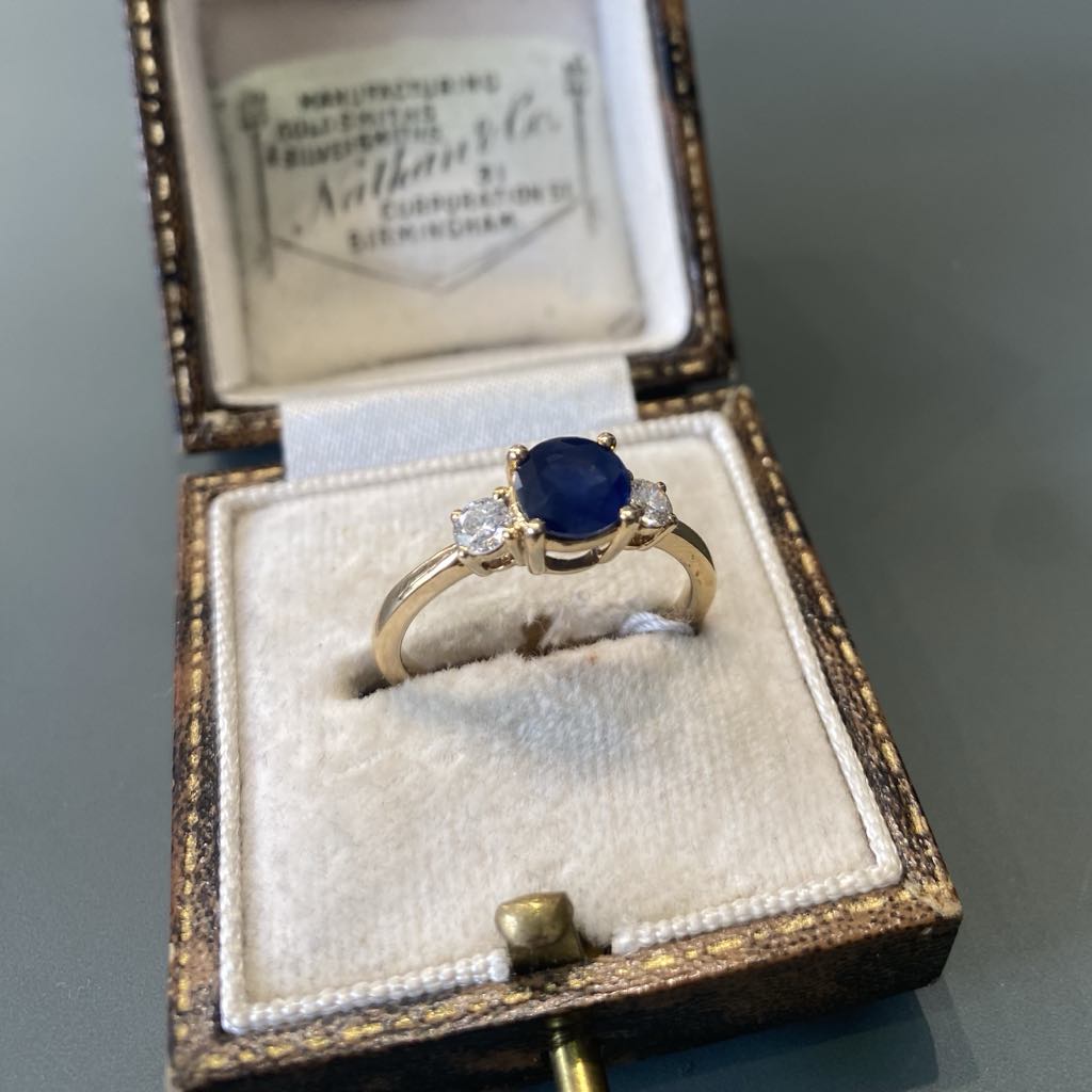 Round sapphire and diamond three stone ring