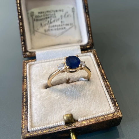 Round sapphire and diamond three stone ring